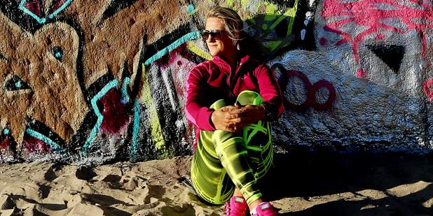Tennis player Victoria Azarenka, sat on a beach, leaning against a graffiti wall | Bentley Motors