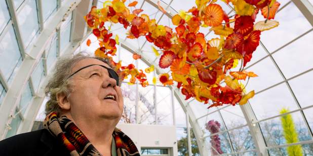 Dale Chihuly admiring his colourful glass art in a glass-roof conservatory | Bentley Motors 