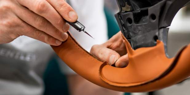 Bentley craftsman hand sewing leather onto a Bentley steering wheel | Bentley Motors